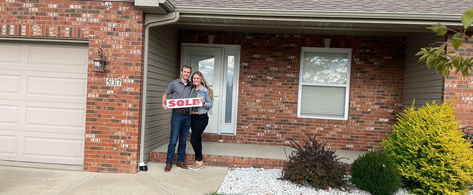 couple standing in front of their new home